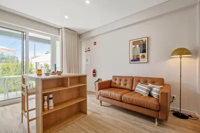 a living room with a couch and a window at Modern Studio Steps From Beach in Ponta do Sol