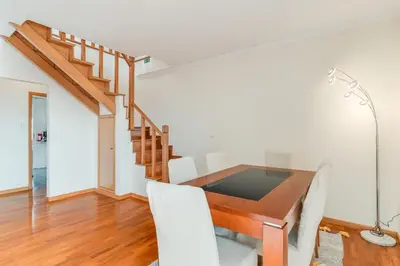 a dining room with a wooden table and white chairs at Ribeira brava - duplex sea view in Ribeira Brava