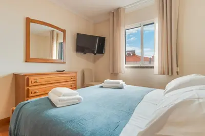 a bedroom with a bed and a mirror and a tv at Ribeira brava - duplex sea view in Ribeira Brava