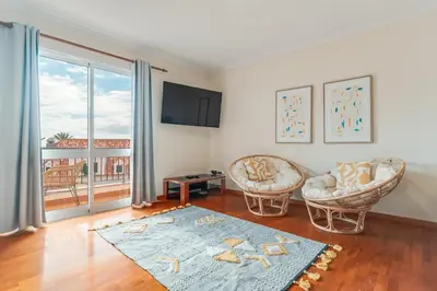 a living room with two chairs and a large window at Ribeira brava - duplex sea view in Ribeira Brava