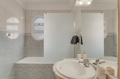 a white bathroom with a sink and a tub at Ribeira brava - duplex sea view in Ribeira Brava