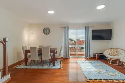 a dining room with a table and chairs and a television at Ribeira brava - duplex sea view in Ribeira Brava