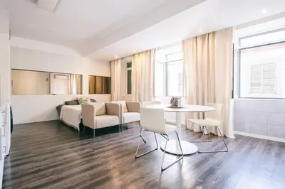 a living room with a couch and a table and chairs at Funchal City Studio in Funchal