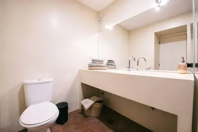 a white bathroom with a toilet and a sink at Funchal City Studio in Funchal
