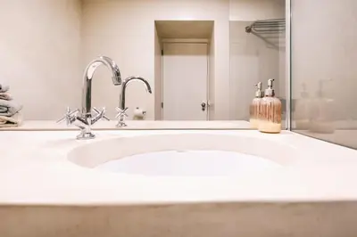 a bathroom with a sink with a soap dispenser on it at Funchal City Studio in Funchal