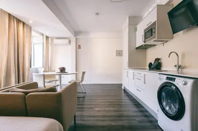 a kitchen with a washing machine in a room at Funchal City Studio in Funchal