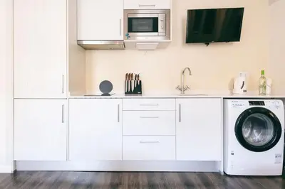 a kitchen with a washing machine and a microwave at Funchal City Studio in Funchal
