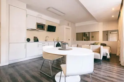 a kitchen and dining room with a white table and chairs at Funchal City Studio in Funchal