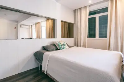 a bedroom with a white bed and a window at Funchal City Studio in Funchal