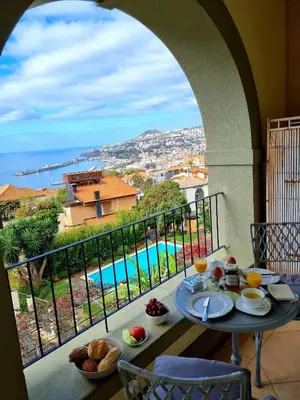 a balcony with a table with food and a view at Elegant and Relaxing Seaview Apartment with Pool in Funchal