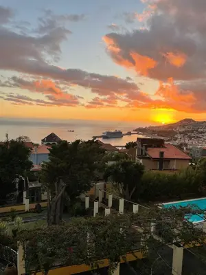 a view of the sunset from the balcony of a resort at Elegant and Relaxing Seaview Apartment with Pool in Funchal