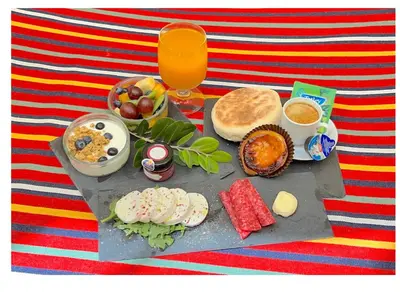 a tray with breakfast foods and a glass of orange juice at Elegant and Relaxing Seaview Apartment with Pool in Funchal