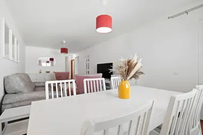 a white dining room with a white table and chairs at Atlantic Paradise in Caniço