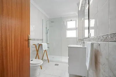 a white bathroom with a toilet and a sink at Atlantic Paradise in Caniço