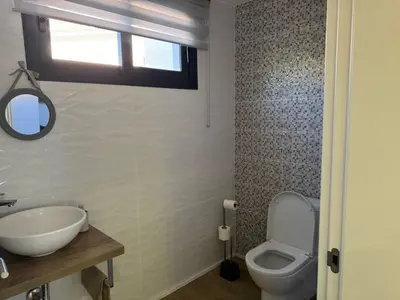 a bathroom with a toilet and a sink and a window at D - DELIGHTFUL Cottage with FREE Private Parking in Machico