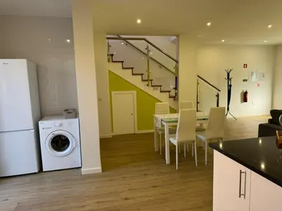 a kitchen and dining room with a table and a washing machine at D - DELIGHTFUL Cottage with FREE Private Parking in Machico