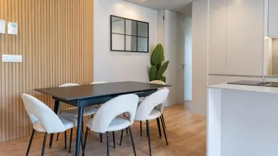 a dining room with a black table and white chairs at Orion Calheta Hills by LovelyStay in Estreito da Calheta