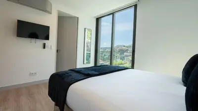 a bedroom with a white bed with a large window at Orion Calheta Hills by LovelyStay in Estreito da Calheta