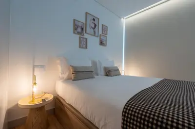 a bedroom with a bed and a table and a lamp at Orion Calheta Hills by LovelyStay in Estreito da Calheta