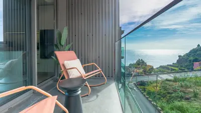 a balcony with a chair and a view of the ocean at Orion Calheta Hills by LovelyStay in Estreito da Calheta