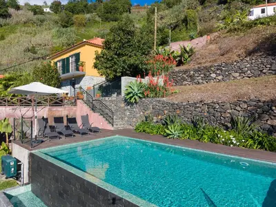 a swimming pool in front of a house at Casa da Laranja by Holiday Rental Madeira in Tábua