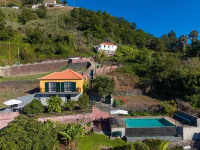 a house on a hill with a swimming pool at Casa da Laranja by Holiday Rental Madeira in Tábua