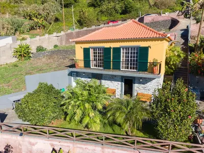 a yellow and green house with a balcony at Casa da Laranja by Holiday Rental Madeira in Tábua