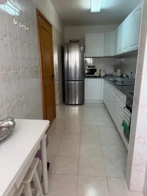 a kitchen with white cabinets and a stainless steel refrigerator at Ajuda Mar Holidays in Funchal