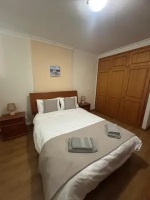 a bedroom with a large bed with two towels on it at Ajuda Mar Holidays in Funchal
