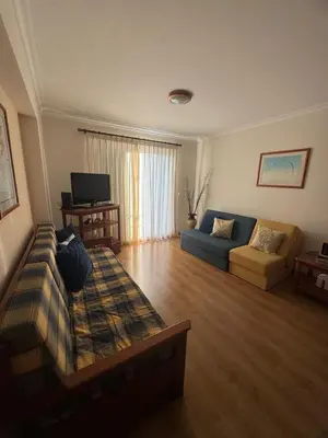a living room with a couch and a tv at Ajuda Mar Holidays in Funchal