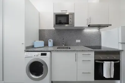 a kitchen with a washing machine and a microwave at Residência Lord Freitas I by An Island Apart in Funchal