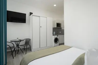 a bedroom with a bed and a table and a kitchen at Residência Lord Freitas I by An Island Apart in Funchal