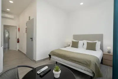 a bedroom with a bed and a table and a room at Residência Lord Freitas I by An Island Apart in Funchal