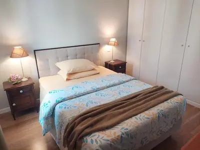 a bedroom with a bed with two night stands and two lamps at Funchal bay incredible view with pool in Funchal