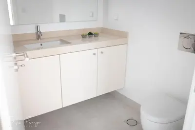 a white bathroom with a sink and a toilet at Funchal bay incredible view with pool in Funchal