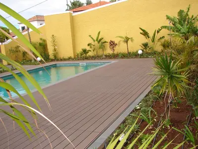 a swimming pool next to a yellow building at Funchal bay incredible view with pool in Funchal
