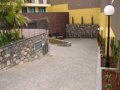 a stone walkway in front of a building at Funchal bay incredible view with pool in Funchal