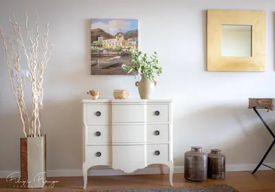 a white dresser with a painting on the wall at Funchal bay incredible view with pool in Funchal