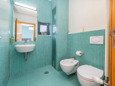 a blue tiled bathroom with a toilet and a sink at Contemporary villa with private pool #1987 in Lagos