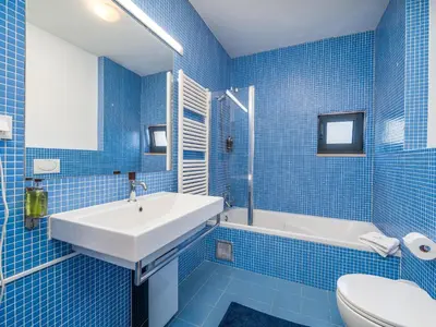 a blue tiled bathroom with a sink and a tub at Contemporary villa with private pool #1987 in Lagos