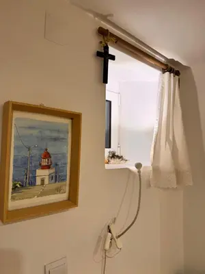 a cross hanging on a wall next to a window at Mango Tree House Funchal Madeira Island in Funchal