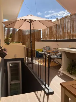 a balcony with an umbrella and a table at Mango Tree House Funchal Madeira Island in Funchal