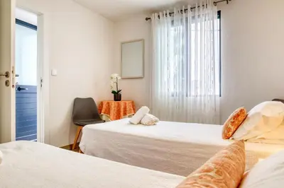 a room with two beds and a table and a window at Funchal Hills, a Home in Madeira in Funchal