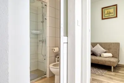 a bathroom with a toilet and a glass shower at Funchal Hills, a Home in Madeira in Funchal