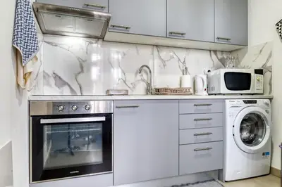 a white kitchen with a sink and a microwave at Funchal Hills, a Home in Madeira in Funchal