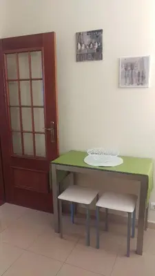 a green table and two chairs and a door at Enchanting and cozy ACHADA PALACE APARTMENT in Funchal