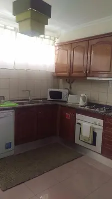 a kitchen with wooden cabinets and white appliances at Enchanting and cozy ACHADA PALACE APARTMENT in Funchal
