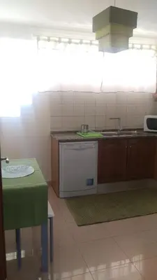 a kitchen with a stove and a sink and a table at Enchanting and cozy ACHADA PALACE APARTMENT in Funchal