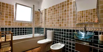 a bathroom with a toilet and a sink and a window at Villa Ocean Wave Calheta - Oversized Pool & Stunning Ocean Views in Calheta