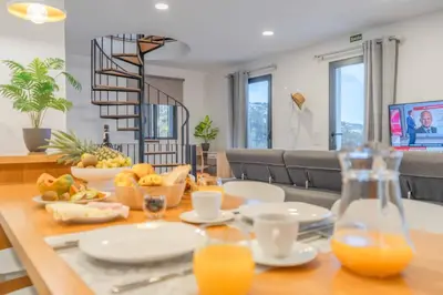 a living room with a couch and a kitchen at A View to Paradise – Spectacular Sea & Bay Views in Funchal